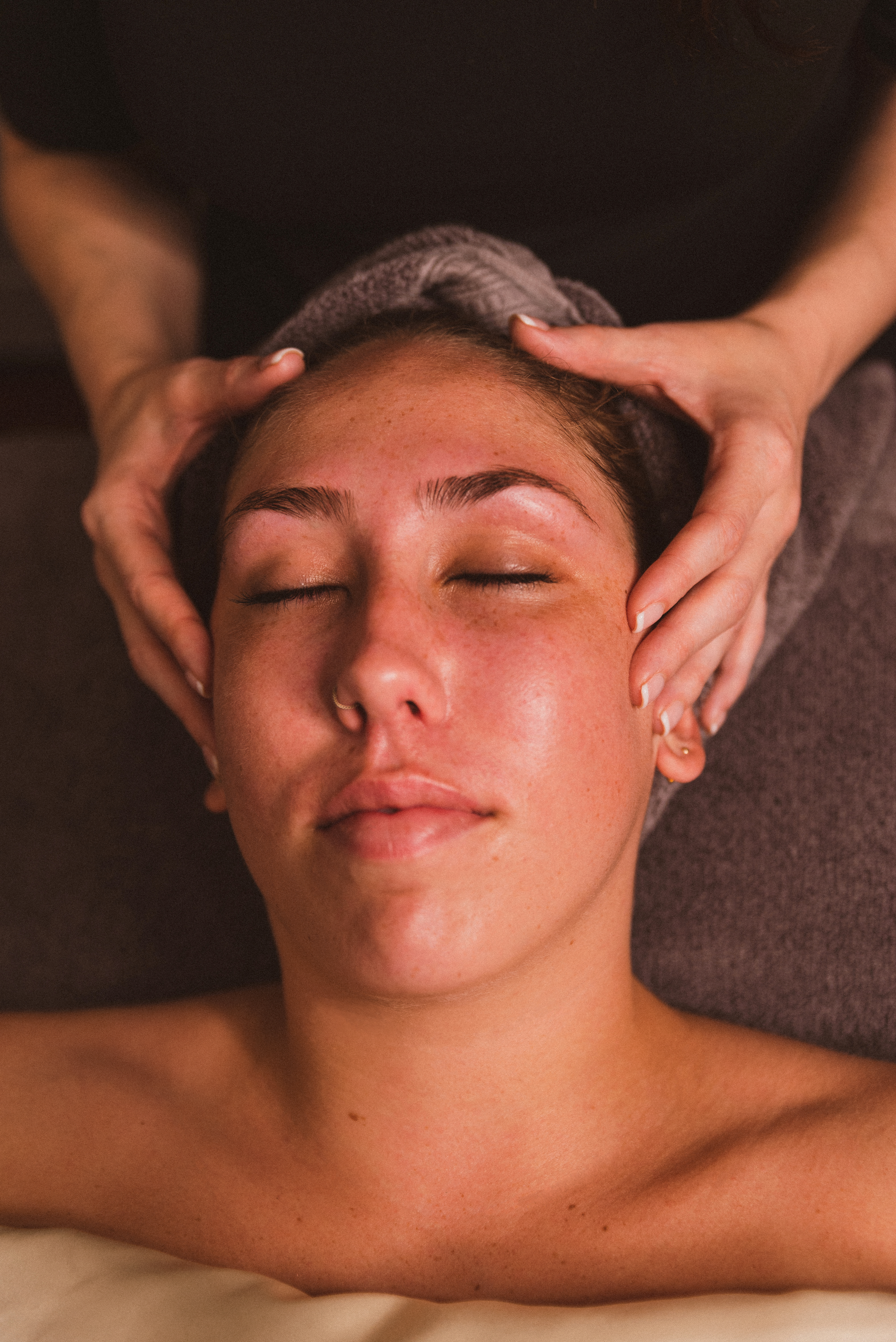 Woman on a table looking relaxed getting a head massage