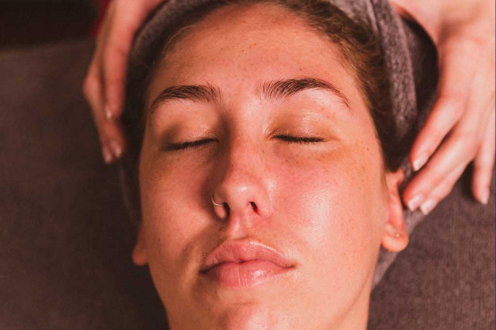 A woman looking relaxed on a table after receiving a facial